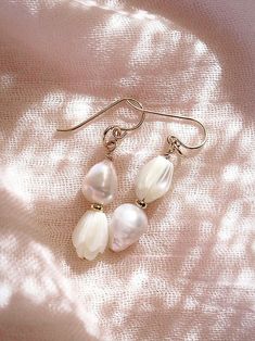 These asymmetrical carved Pikake and Baroque Pearl Earrings make beautiful simple statements. Seemingly plucked straight from the ocean, the luminous, organic white pearls sway and illuminate in the light. Wear these unique pearl, pikake, and gold earrings for a modern upgrade. ✦ DETAILS ✦ ✧ Name: Huali - (hoo A lee) - Pure, bright, gleaming. ✧ 14kt Gold Filled. ✧ Genuine Freshwater Baroque Pearls. ✧ Carved Mother of Pearl Pikake Flowers. ✧ All Ke Aloha Jewelry pieces come packaged thoughtfully, Delicate White Pearl Pierced Earrings, Delicate Pear-shaped White Earrings, Delicate White Pear-shaped Earrings, Pearl Earrings Gold, Flower Earrings Gold, White Pearl Earring, Flower Earring, Baroque Pearl Earrings, Earring Gold