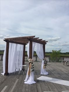 an outdoor wedding setup with white drapes and flowers