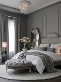 a bedroom with gray walls and white bedding, round rugs and chandelier