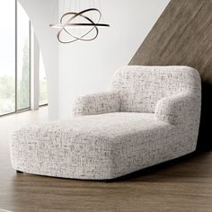 a white chair sitting on top of a hard wood floor next to a lamp and window