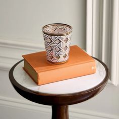 a cup sitting on top of an orange book