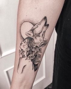 a woman with a wolf tattoo on her arm