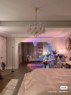 a bedroom with a bed, chandelier and couch