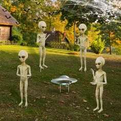 there are four alien statues standing in the grass