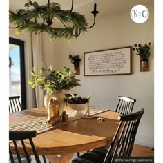 a dining room table with chairs and a potted plant hanging from it's ceiling