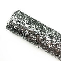 a roll of black and silver glitter on a white background