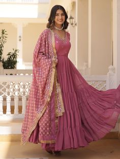 our stunning pink georgette gown, adorned with intricate embroidery and shimmering sequin work. This enchanting ensemble is designed to make you feel like a princess, radiating elegance and charm at every turn.
Available in fully stitched sizes ranging from XS to XXL, this gown ensures a perfect fit for women of all body types. With a generous 15-meter flair and a length of 56 inches, it boasts a graceful silhouette that will captivate hearts wherever you go.
Accompanying this beautiful gown is Pink Georgette Sharara With Sheer Dupatta, Floor-length Embroidered Dress For Wedding And Diwali, Floor-length Embroidered Dress For Wedding During Diwali, Festive Gown With Intricate Embroidery In Georgette, Bollywood Embroidered Georgette Gown, Bollywood Style Embroidered Georgette Gown, Pink Floor-length Dress For Wedding, Pink Dresses With Sheer Dupatta For Festivals, Fitted Embroidered Dress With Mirror Work For Wedding