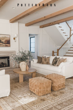 a living room filled with furniture and a fire place under a stair bannister