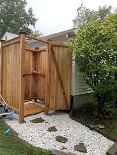 a small wooden outhouse sitting in the middle of a yard