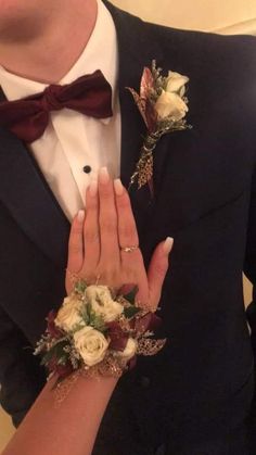 a man in a tuxedo holding his hands together