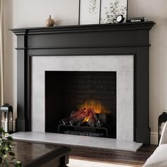 a living room with a fire place in the fireplace and pictures on the wall above it