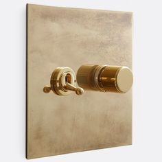 a wall mounted light switch with two knobs