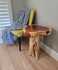 a wooden table sitting next to a yellow chair on top of a hard wood floor