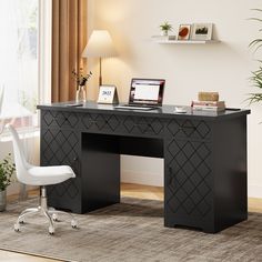 a desk with a laptop on it in front of a window and potted plant