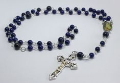 A beautiful five decade rosary made using 6mm and 8mm lapis lazuli gemstone beads. The crucifix measures approximately 5cm by 3cm. Wrapped in tissue paper and presented in an organza gift pouch. Gift Rosary With Silver Round Beads, Silver Beads Rosary As Gift, Silver Beaded Rosary As Gift, Elegant Beaded Rosary For Gift, Elegant Beaded Rosary As Gift, Elegant Beaded Rosary With Round Beads, Elegant Silver Beads Rosary Gift, Elegant Beaded Rosary, Elegant Rosary With Polished Beads As Gift