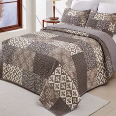 a bed with a brown and white quilt on it