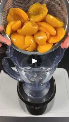 a person holding a strainer full of yellow peppers