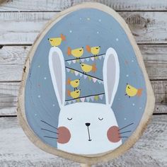 a white rabbit with yellow birds on it's head is standing in front of a wooden