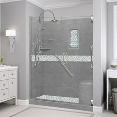 a bathroom with a walk in shower next to a white dresser and mirror on the wall