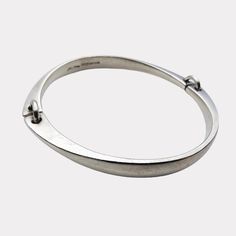 NO. (2.5) Elegant and timeless, this silver bracelet designed by Bent Gabrielsen Pedersen for Hans Hansen exemplifies the sophistication of mid-century Scandinavian design. Crafted in Denmark during the 1960s, this piece features a clean, minimalist aesthetic with two linked segments connected by silver hoops, creating a subtly expressive form that sits gracefully around the wrist. A perfect addition for collectors of mid-century modern or Scandinavian jewelry, this bracelet is both a stylish ac Classic Metal Bangle With Polished Finish, Modern Sterling Silver Oyster Bracelet For Formal Occasions, Formal Modern Sterling Silver Bracelet, Modern Polished Sterling Silver Bracelet, Contemporary Sterling Silver Bangle Bracelet For Formal Events, Contemporary Sterling Silver Bangle For Formal Occasions, Timeless Sterling Silver Bracelet With Polished Finish, Timeless Silver Bangle With Polished Finish, Modern Hallmarked Sterling Silver Bracelet For Formal Occasions