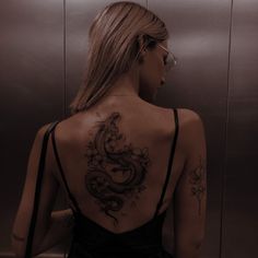 a woman with a dragon tattoo on her back