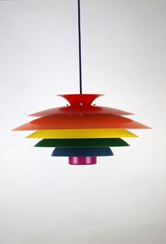 a multicolored light hanging from a ceiling fixture in a white room with no walls