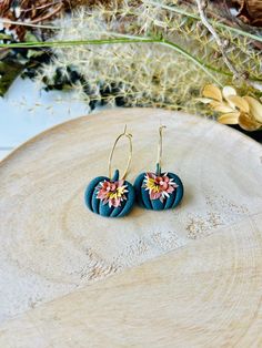 These fun pumpkin hoop earrings have been handmade with polymer clay. All floral detail work is completely done by hand giving each pair a unique look! These are truly one of a kind! You can choose from gold plated stainless steel, antiqued brass or regular stainless steel hoops. All hoops are nickel free, making these great for sensitive ears. The hoops are about 1 inch in diameter. The clay pumpkins are about 1 inch in width. The total length of the earrings is about 1.5 inches. These earrings are super lightweight and so comfortable to wear! Very cute for fall and Halloween! Be sure to check out our shop for more colors! www.etsy.com/shop/theglassbird Also come like our facebook page to receive updates on new items, coupon codes and future giveaways! https://www.facebook.com/TheGlassBir Whimsical Handmade Clay Earrings, Gold Whimsical Polymer Clay Earrings, Whimsical Gold Polymer Clay Earrings, Hoop Earrings In Polymer Clay For Gift, Handmade Small Hoop Earrings In Polymer Clay, Handmade Polymer Clay Dangle Hoop Earrings, Handmade Unique Polymer Clay Flower Earrings, Unique Handmade Polymer Clay Flower Earrings, Handmade Whimsical Polymer Clay Flower Earrings