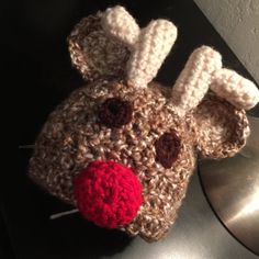 a crocheted reindeer hat with a red nose