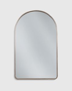 an arched mirror on a white wall