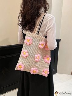 a woman is holding a handbag with pink flowers on the front and back side