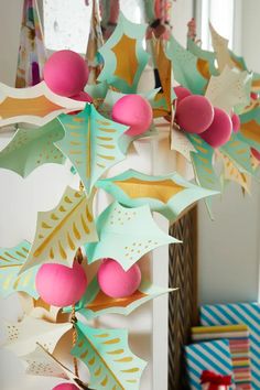 a bunch of paper decorations hanging from the ceiling in front of a christmas tree ornament