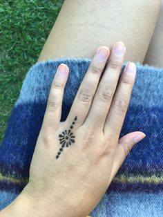 a woman's hand with a flower tattoo on it