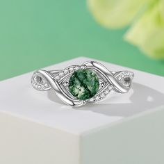 This sterling silver ring features a round green moss agate stone as the main stone that radiates a mysterious and enchanting glow. Symbolizing calm and vitality, the green moss agate's unique colors and textures seem like a painting of nature, while the infinity symbol's design symbolizes endless emotion and commitment. Whether worn as everyday jewelry or as a gift for a special occasion, this moss agate ring will add a unique charm to your appearance.Weight: 3.6 gMaterial: 925 SilverPlating Color: Silver Green Round Crystal Promise Ring, Green Crystal Round Promise Ring, Green Emerald Crystal Ring, Nature-inspired Green Emerald Ring For May Birthstone, Green Round Crystal Ring Fine Jewelry, Green Crystal Round Ring Fine Jewelry, Green Round Crystal Ring In Fine Jewelry Style, Elegant Green Moss Agate Rings, Green Sterling Silver Crystal Ring