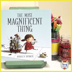 the most magnificent thing book sitting on top of a desk next to some crayons