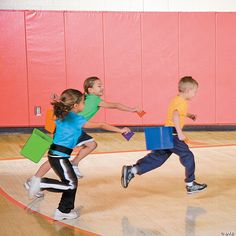 three children running on a basketball court with their arms in the air and carrying boxes