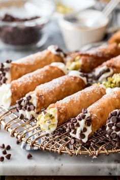 chocolate chip covered crepes on a cooling rack with other desserts in the background