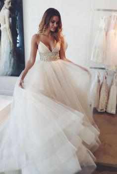 a woman in a white dress is looking at her wedding dress