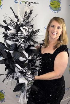 a woman in a black and white dress is holding a large bunch of hair bows