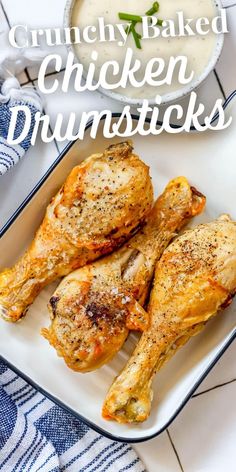 baked chicken drumsticks on a white platter with ranch dressing in the background