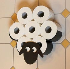 a bunch of toilet paper sitting on top of a white tiled floor next to a pile of black and white rolls