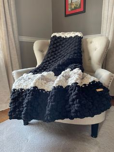 a black and white crocheted blanket sitting on top of a chair