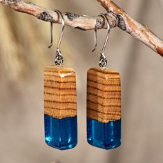 Modern trends merge with the magical aura of the Armenian forests in this geometric design made for those with a mystic soul. Artisan Kamo Galstyan uses apricot wood to create these dangle earrings, whose rectangular shape gracefully includes blue resin accents as a symbol of fantasy and imagination. The pieces also have sterling silver hooks for a glorious display of beauty. Mystic Soul, Wood Resin Jewelry, Wood And Resin, Mens Jewelry Necklace, Wood Resin, Wood Earrings, Modern Earrings, Geometric Earrings, Jewelry Packaging