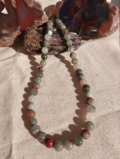 This listing is for a 16" adjustable-length African bloodstone necklace. This necklace is a lovely gray and red color with some stones appearing semitransparent and translucent. The necklace would suit a man or a woman equally well. Do bear in mind the length. If your neck is over 18", this item won't fit. I can adjust it per your request prior to shipping it if you need a looser fit. African bloodstone is also known as Seftonite or Vulcan jasper. It is a kind of chalcedony associated with the h Gray Gemstone Beads Necklaces For Gifts, Gray Gemstone Beads Necklace For Gift, Adjustable Gray Gemstone Beads Necklace, Adjustable Gray Necklace With Gemstone Beads, Adjustable Gray Gemstone Beaded Necklace, African Bloodstone, Bloodstone Necklace, Heart Chakra, Red Color