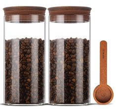 two glass jars filled with coffee beans next to a wooden spoon