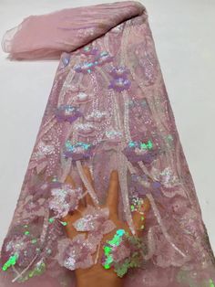 a doll is wearing a pink dress with sequins on it's arms