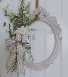 a wreath with flowers hanging on the front door