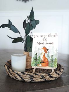 a card on a tray with a candle next to it and a potted plant