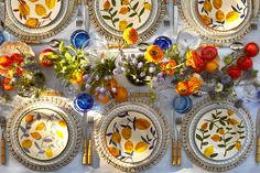 the table is set with colorful plates and flowers