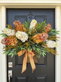 a front door decorated with flowers and greenery