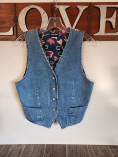 Vintage GUESS Jeans Vest  *  Faded Blue Denim at Front  *  Muted Floral Design on Back  *  4 Buttons at Front with GUESS  *  Small Working Pockets *  Made in USA *  Label Size M *  Strap and Buckle At Back Actual Measurements:   34"  Bust    32"  Mid Section Waist Area    18" to 20" Length - Shoulder to Side Hem and Front Hem Remember you need to fit within the measurements given for the best fit, keeping into consideration decade/style and fit of a vintage garment.   Measure a similar item in your closet as reference.    Clothing Items are measured across seam to seam and doubled for your convenience where necessary.  Colors do not always photograph well and I try to describe actual colors where necessary.   Review All Photos Carefully as they are a part of the description Ships Promptly Vintage Denim Vest, Jean Vest, Faded Denim, Guess Jeans, Vest Outfits, Label Sizes, Denim Vest, Womens Vest, Vintage Denim